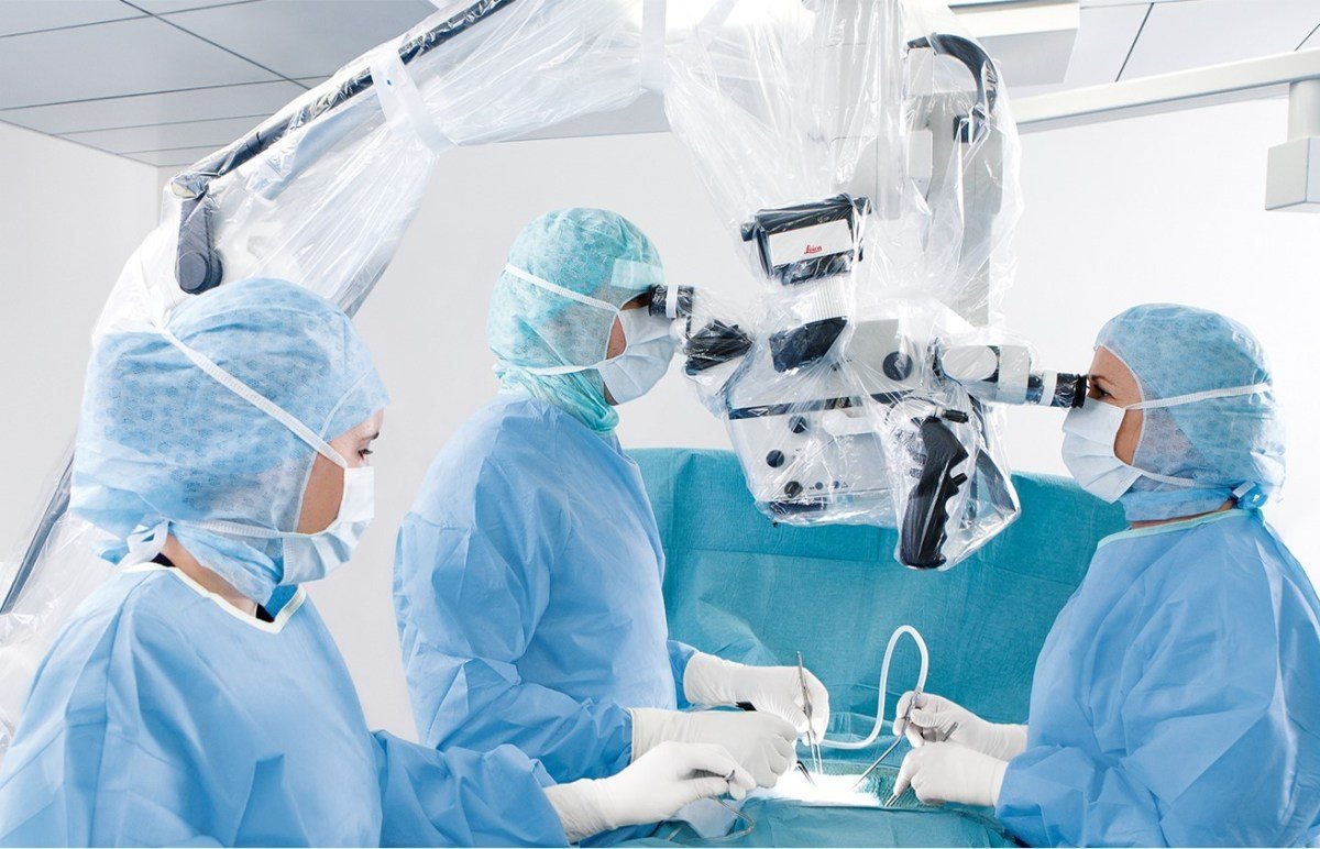 Surgical team using a draped Leica microscope